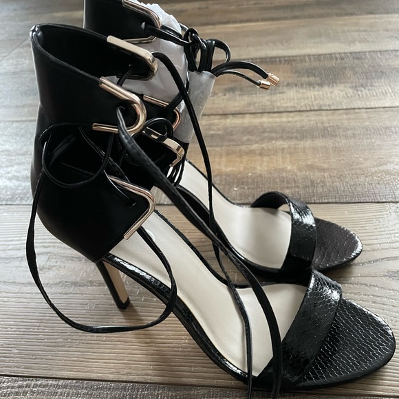 NWOT Lace up black heels with gold detailing .